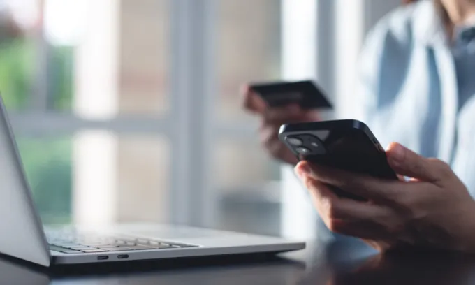 Close-up of man paying the average mobile phone bill in Australia.