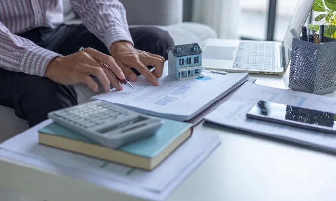 Person planning their budget for rate hikes.