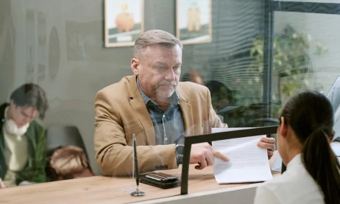 A man at a bank branch counter.