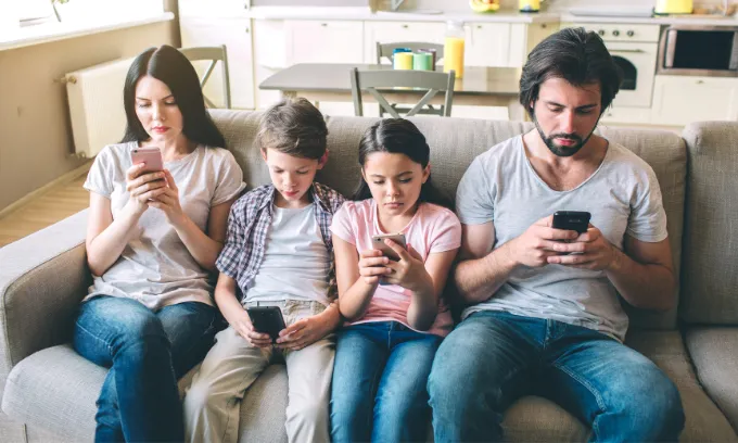 Family of four using their mobile phone plans
