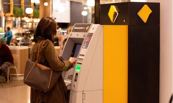 Woman withdrawing from her CBA savings account.