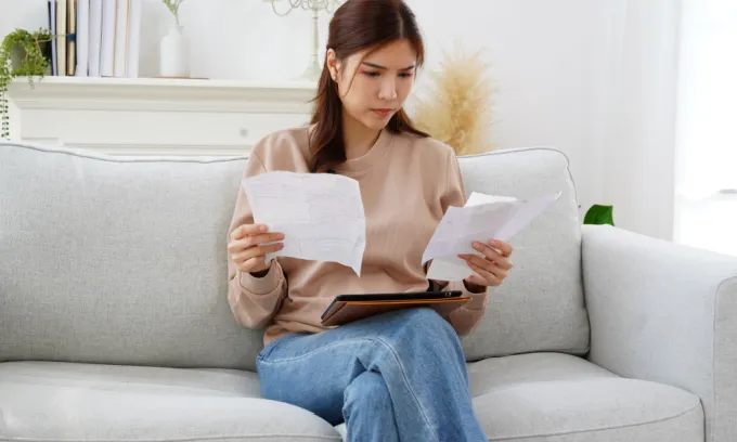 Woman looking at her bills concerned.