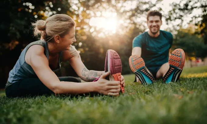 A man and woman stretch after exercising