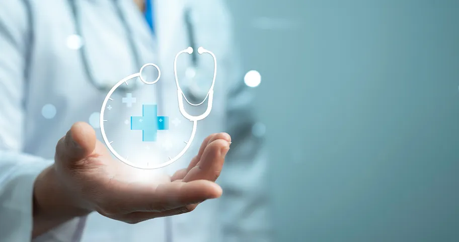 Person in doctor's white coat with graphic of blue cross and stethoscope in hand.