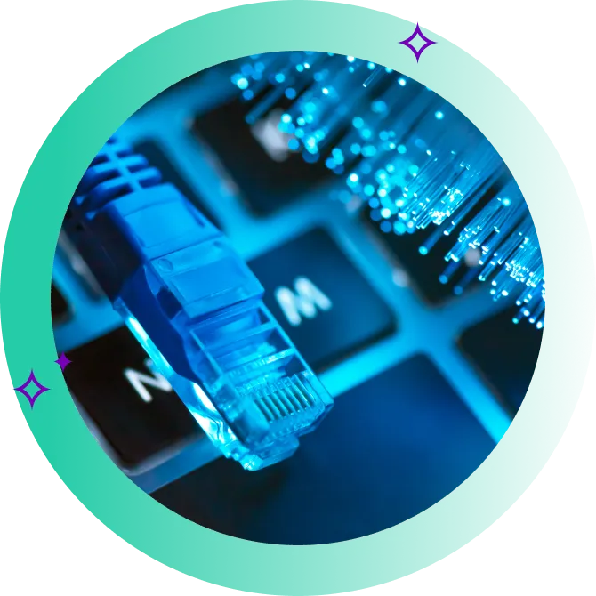 Blue ethernet cable connector alongside silica optical fibers on top of a laptop keyboard.