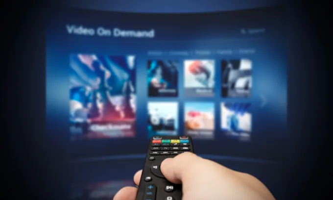 A held remote navigating a streaming service on the TV