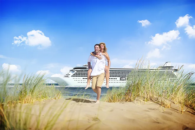 Couple on beach against cruise liner backdrop