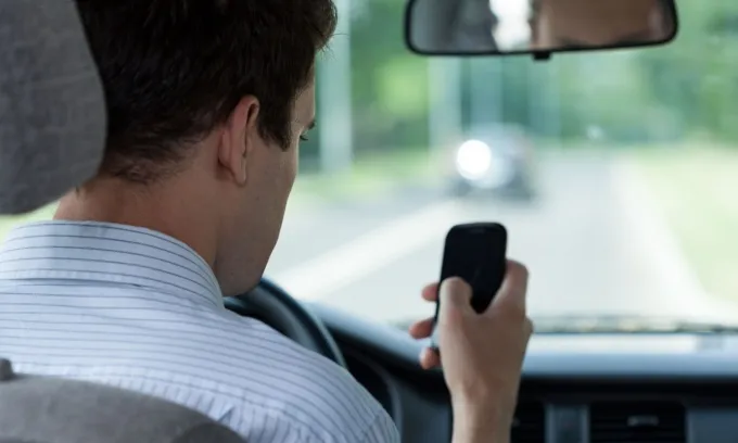 Man looking at phone while driving.