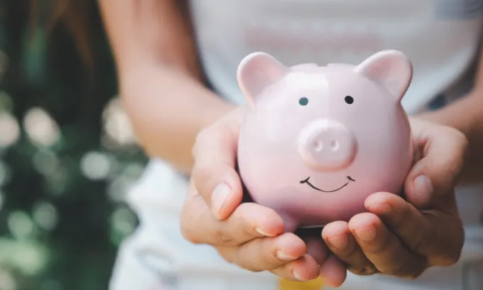 Woman holding a piggy bank.