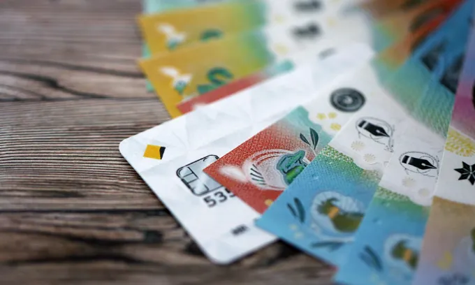 A close-up of a CBA card and Australian cash.
