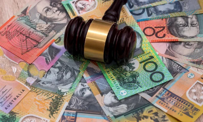 A gavel sitting on Australian bank notes. 
