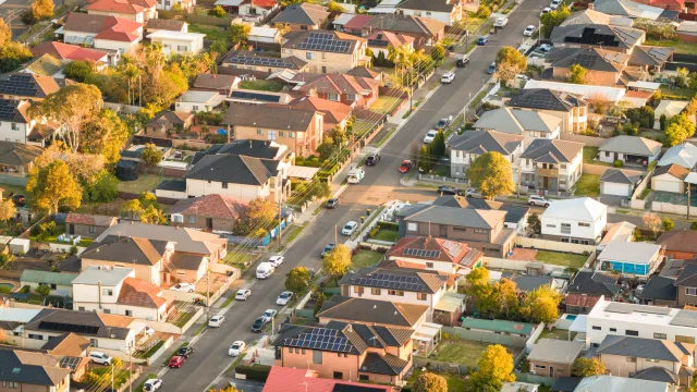 Aerial view of suburbs with rooftop solar panels in the middle of the day