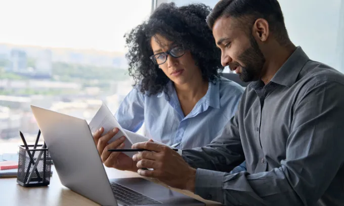 Two people reading bill