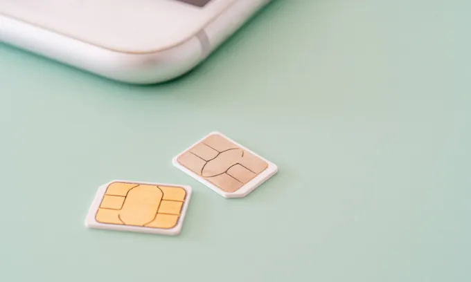 Two SIM cards next to mobile phone