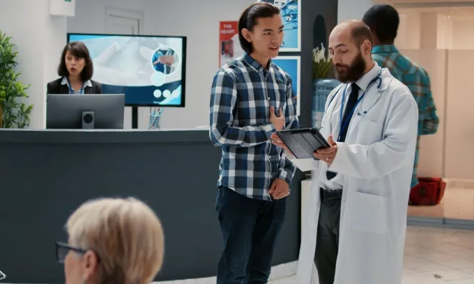 A doctor discusses health insurance excess payments with a patient.