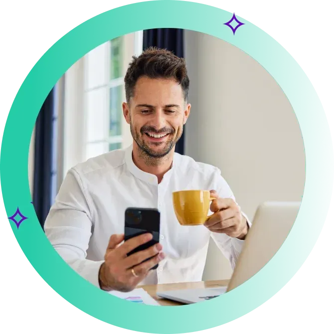 Happy man checking phone while drinking a cup of coffee.