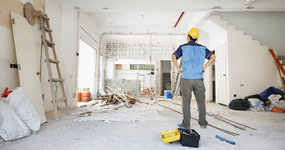 Man in hard hat inside drastic home renovation site