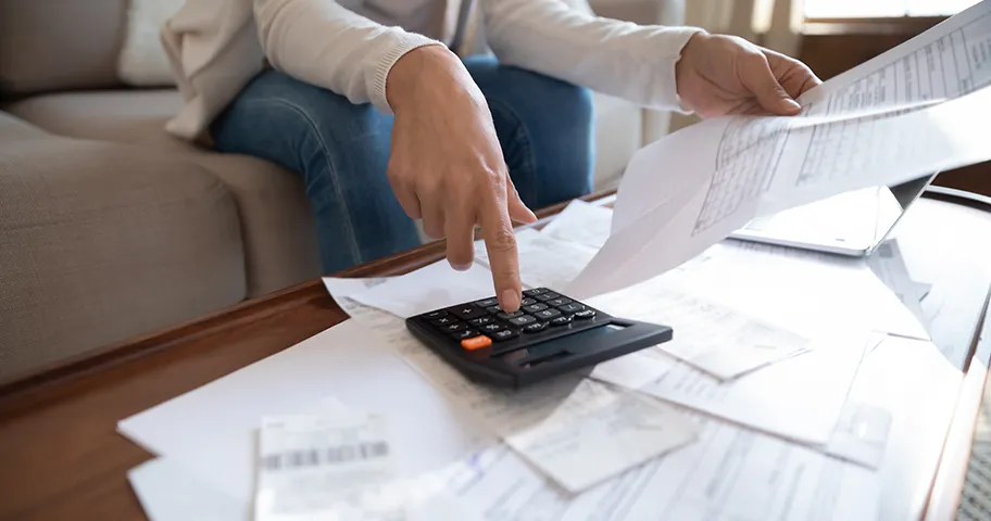 Close up of woman working out her insurance paperwork.