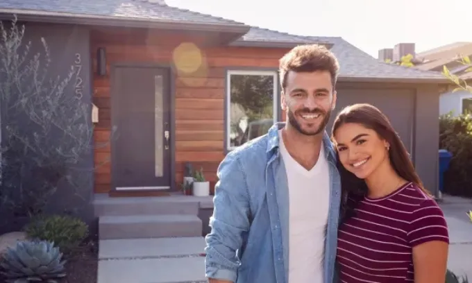 Couple standing in front of their house's porch