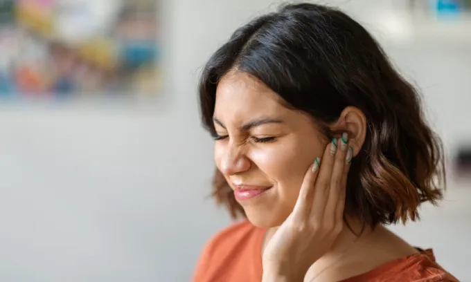 A woman suffers from an ear infection.