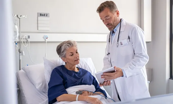 A doctor explains the cost of staying in hospital to a patient.