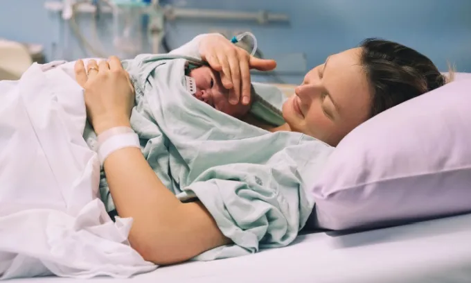 A woman holds her new born baby close to her chest