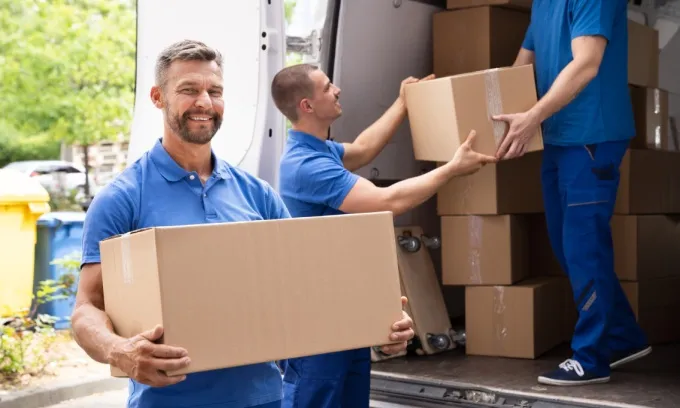 Removalists loading and removing boxes from the back of a truck