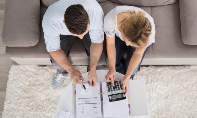 Couple sitting on the couch planning their finances after new RBA decision. 