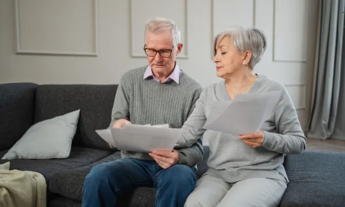 Older couple looking upset at bills. 
