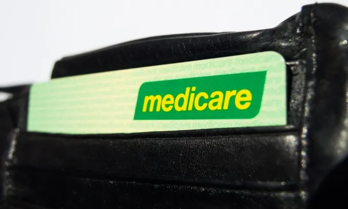 A green Medicare card in a black leather wallet