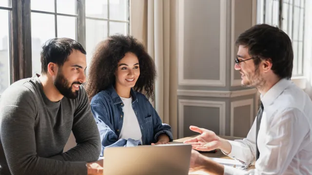 Mortgage broker helping a happy couple refinance