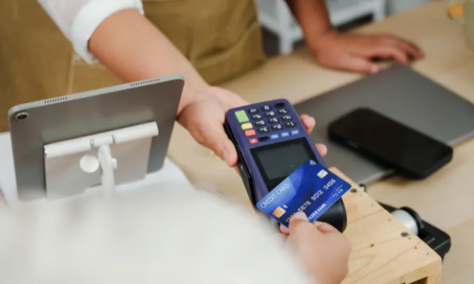 Person tapping their rewards credit cards.
