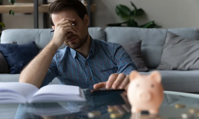 Middle age man looks stressed while looking at bills.