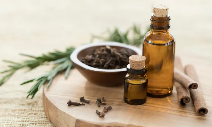A wooden board with a few glass bottles with essential oils in them representing naturopathy.