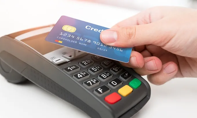 Person tapping rewards credit card