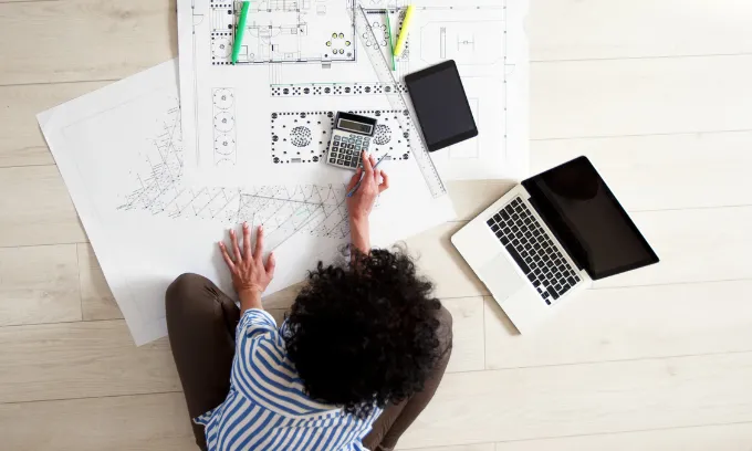 A woman looking at plan drawings of her new off-the-plan property