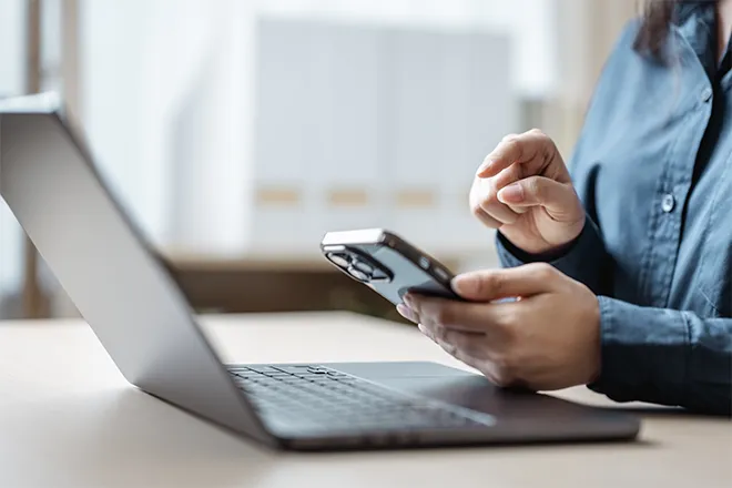 Close-up woman using online banking on laptop and phone