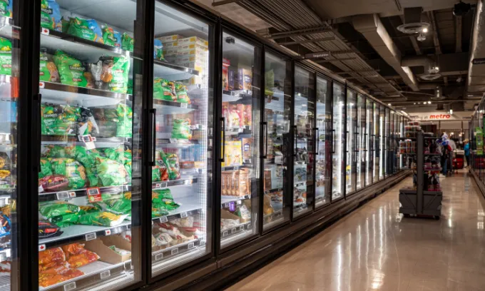 View of frozen food products in supermarket freezer aisle.