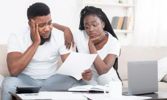 Couple looking at mortgage bill unhappily.