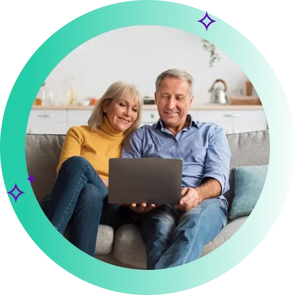 Two people look at computer and smile