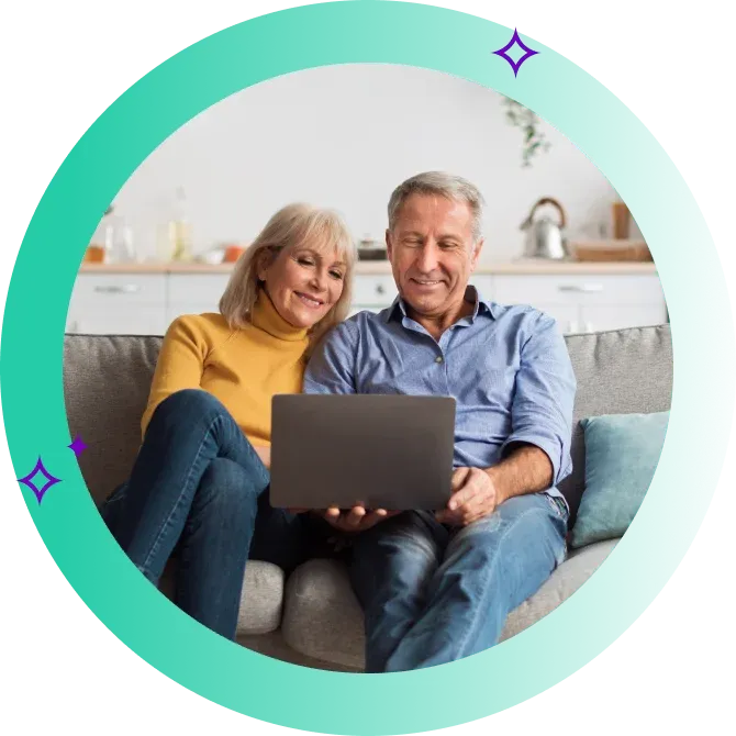 Two people look at computer and smile