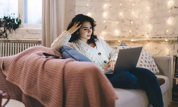 Woman looking at laptop with slow NBN speeds