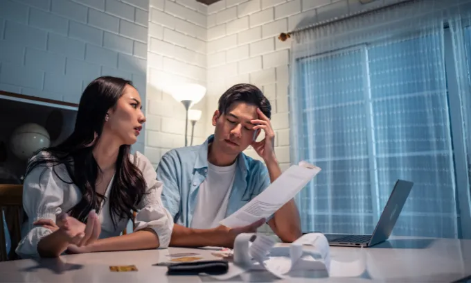 Young couple looking upset with their finances.