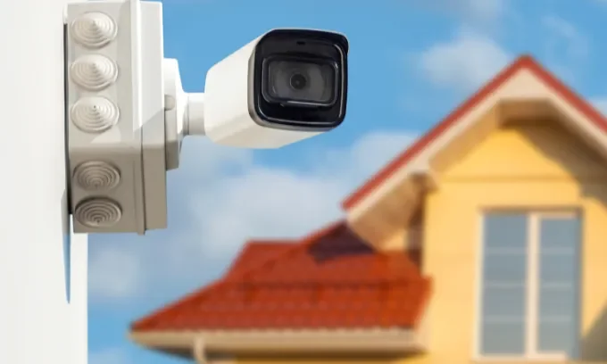 A close up of a security camera on the outside of a home. 