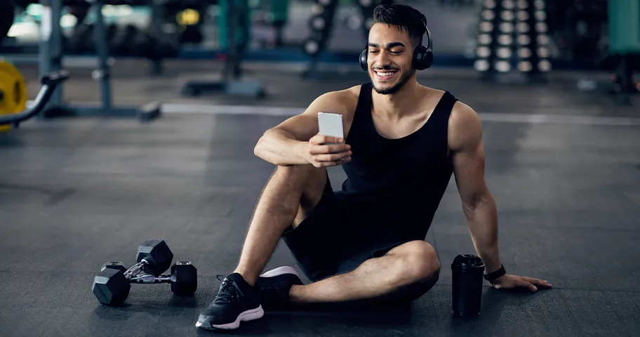 Man in gym looking at his phone
