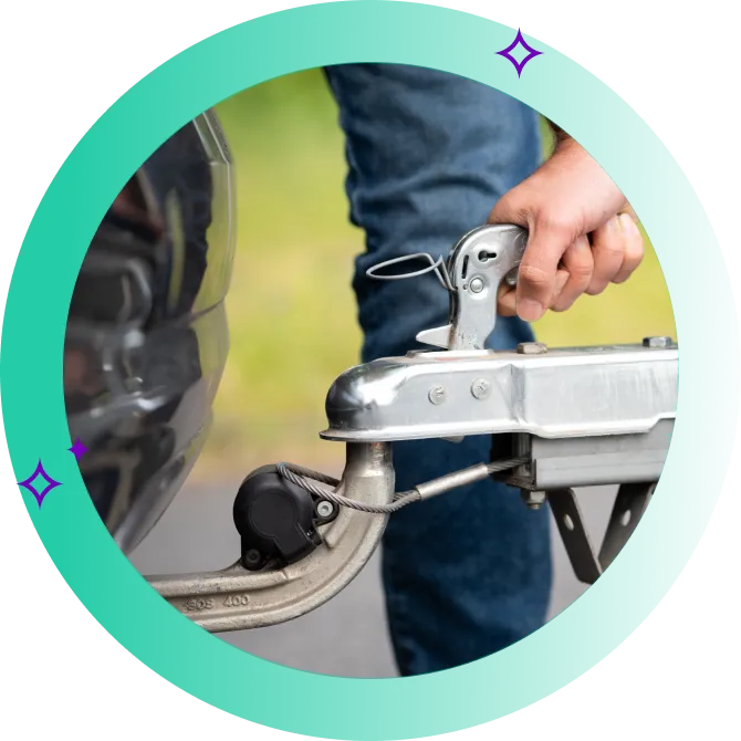 A male's hand detaching a trailer that's attached to the rear of his vehicle