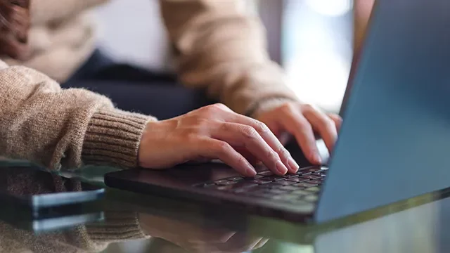 Close up of person searching and comparing transaction accounts on their laptop.
