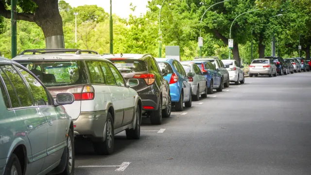 Cars parked under trees on a street in Melbourne, Australia.