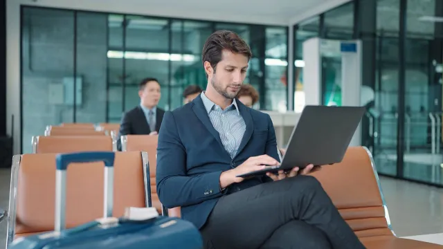 A businessman works on his laptop at the airport