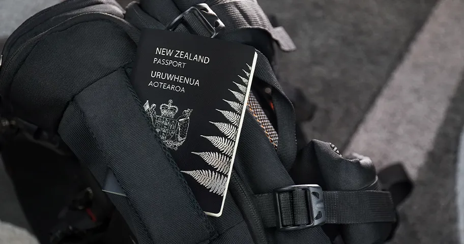 New Zealand passport on black travel bag.